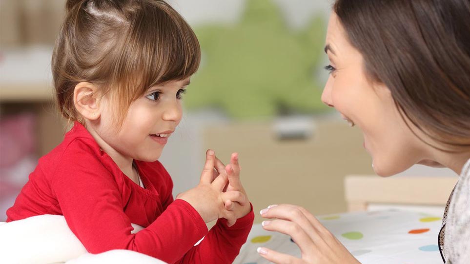 یک مادر و دختربچه روبروی هم قرار دارند و با خوشحالی در حال حرف زدن هستند. 
