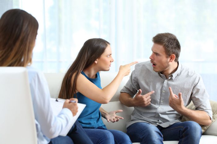 یک زوج کنار هم نشسته اند، خانم با عصبانیت به آقا نگاه کرده و دستش را به سمت صورت او گرفته و مرد تعجب کرده و با دو دست، خودش را نشان می دهد. یک روانشناس خانم نیز روبروی آنها نشسته است